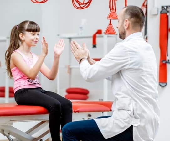 A young girl doing physical therapy with instruction from a chirospot expert